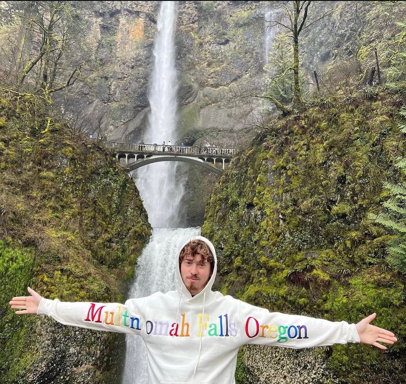 Conner Helm outdoors in front of Multnomah Falls