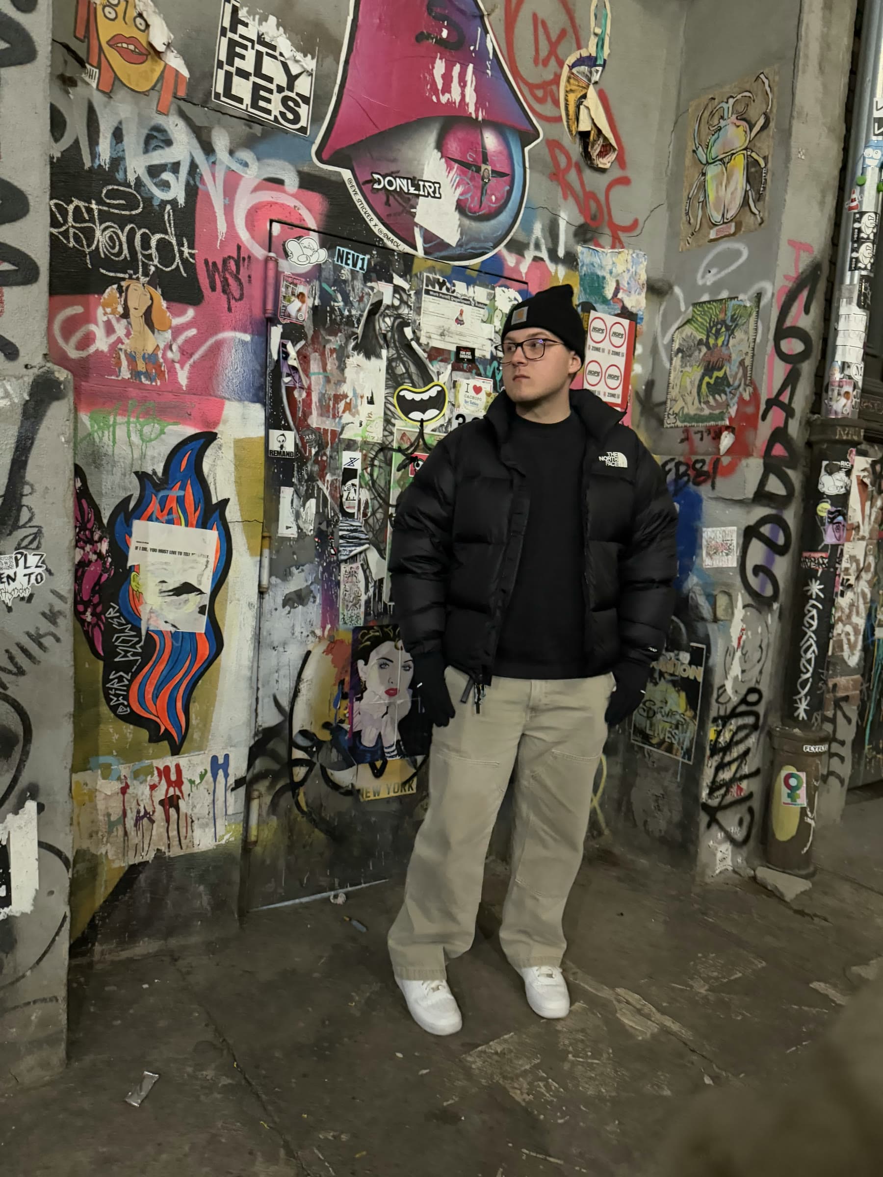 Steven Pereira standing in front of a colorful mural wall