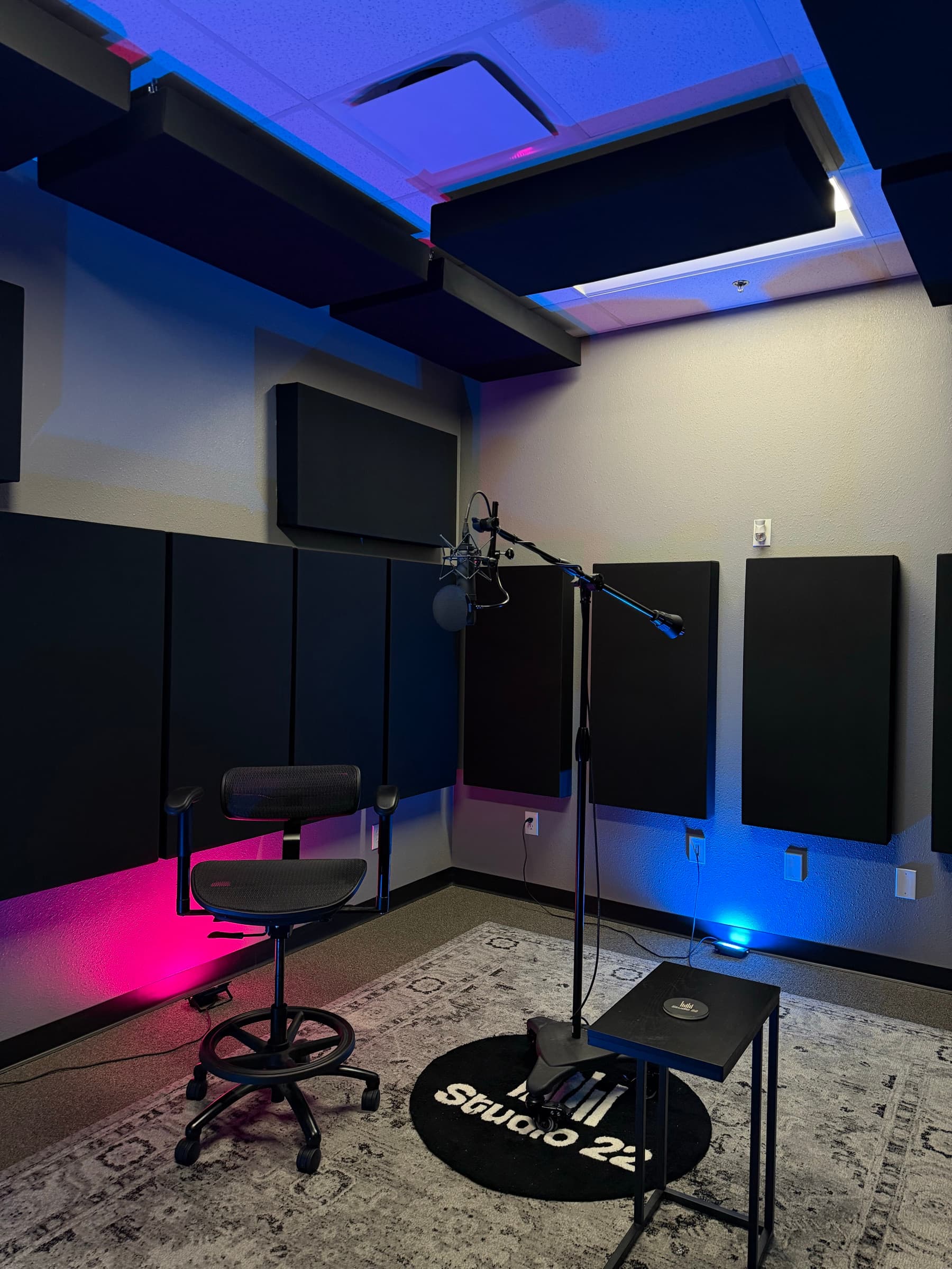 Studio 22 recording room with acoustic treatment, microphone stand, and artist seating